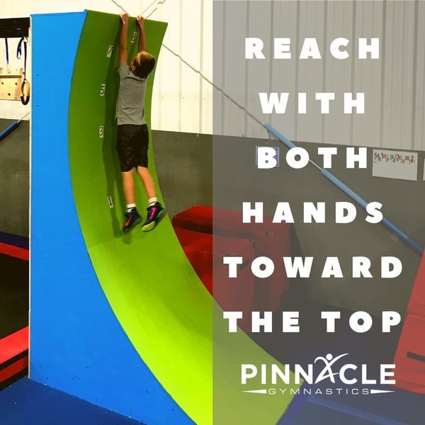 A young boy is hanging from a warped wall.