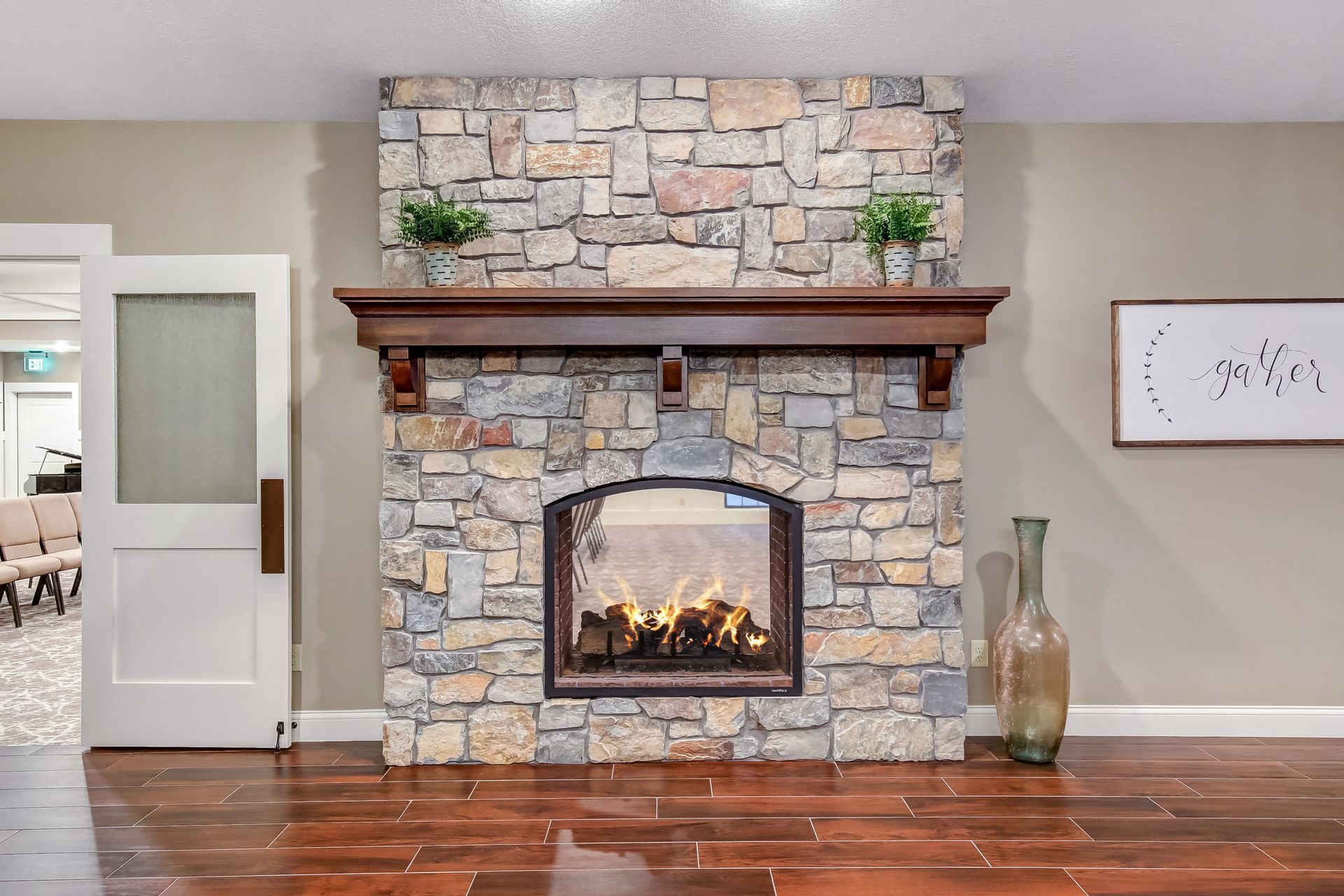 A stone fireplace with a wooden mantle in a living room