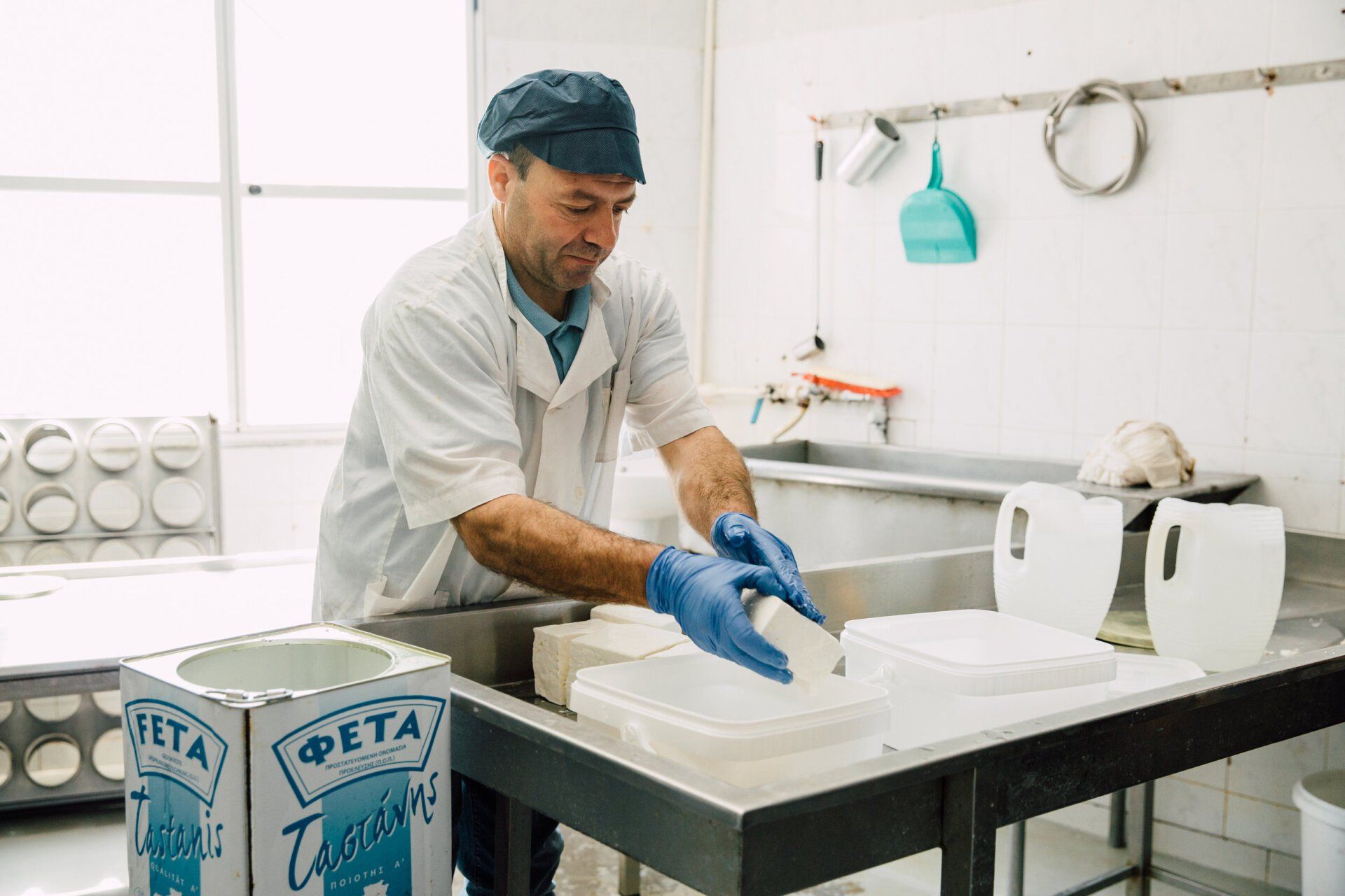 a man is making feta cheese in a kitchen .
