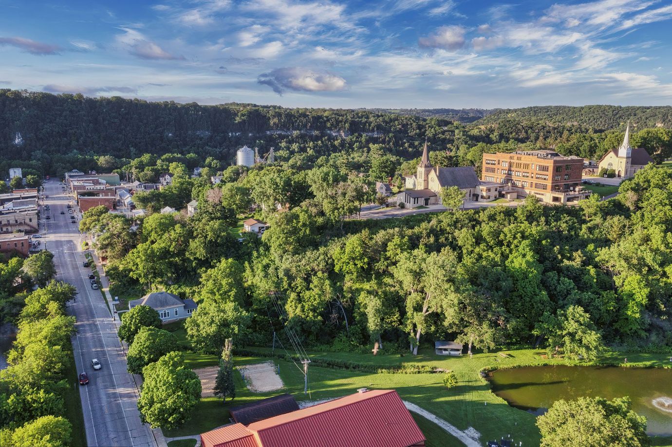 Aerial view of a historic church with twin domes at sunset in a densely populated urban residential neighborhood.