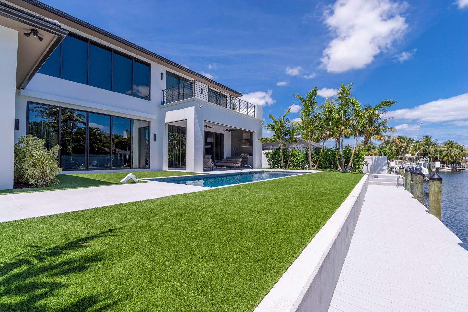 A large white house with a swimming pool in the backyard.