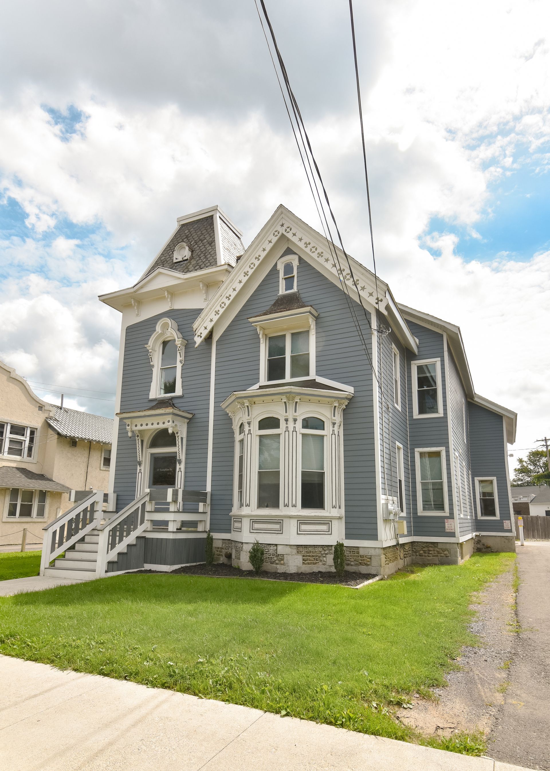 17 Tompkins – Ornate blue Victorian-style house with decorative trim and large front windows.