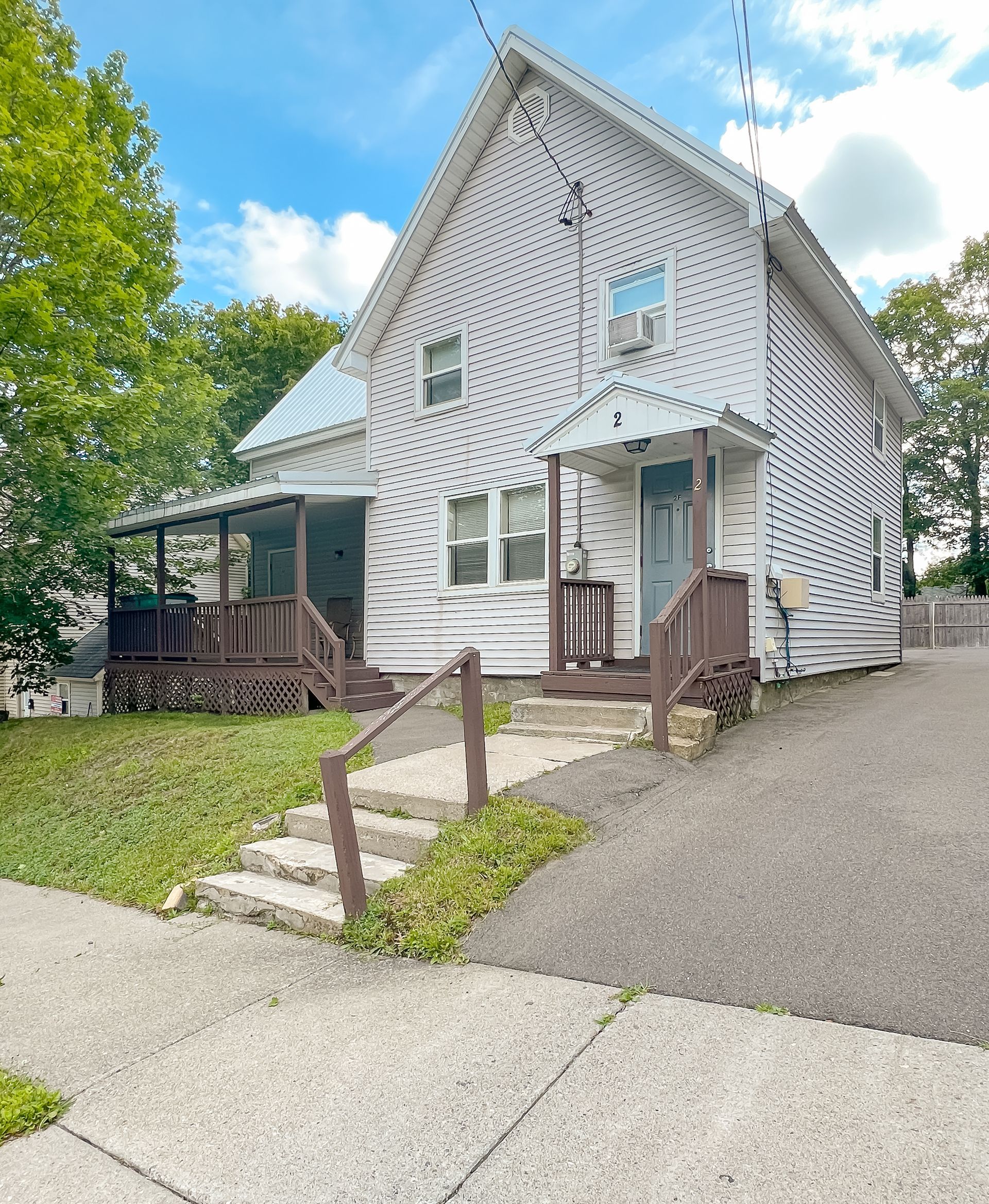 2 Stevenson – Light-gray two-story house with small front porch and driveway along the side.
