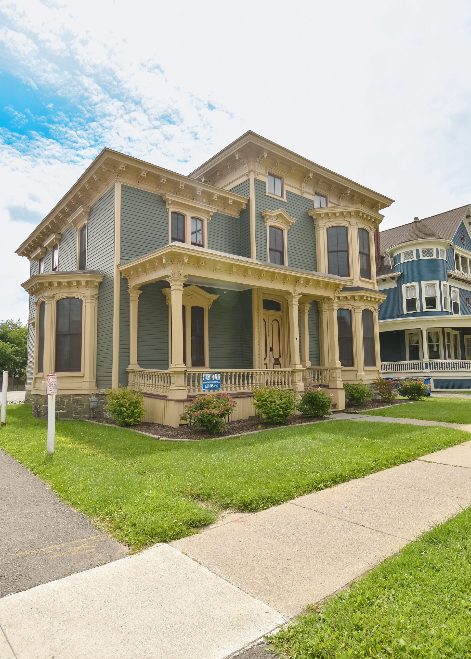 21 Tompkins – Elegant historic-style blue house with ornate cream trim and a landscaped front yard.