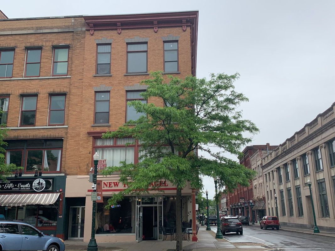 33 Main – Multi-story brick commercial building with storefronts on Main Street and a tree in front.
