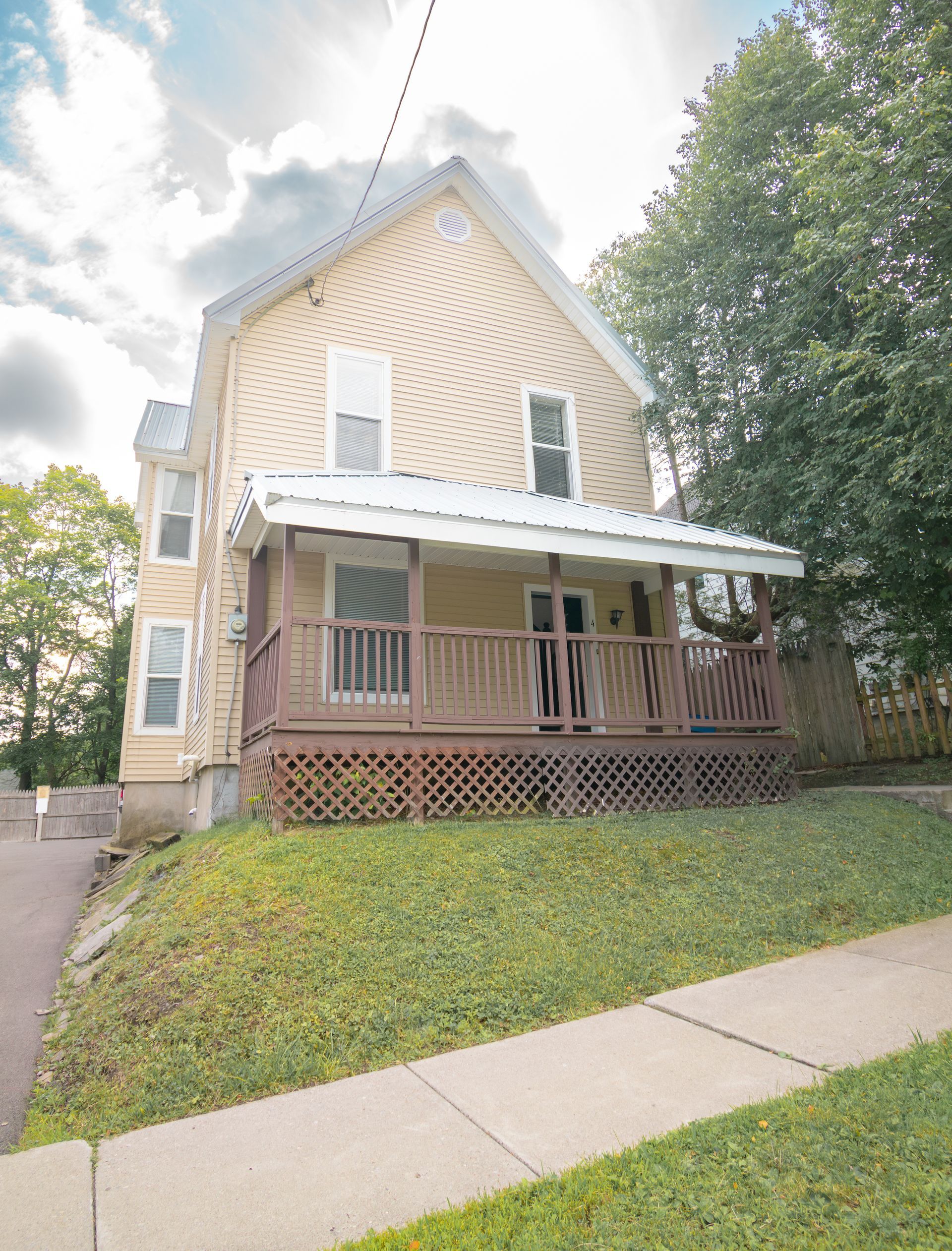 4 Stevenson – Beige two-story house with a covered wooden front porch and lattice skirting.
