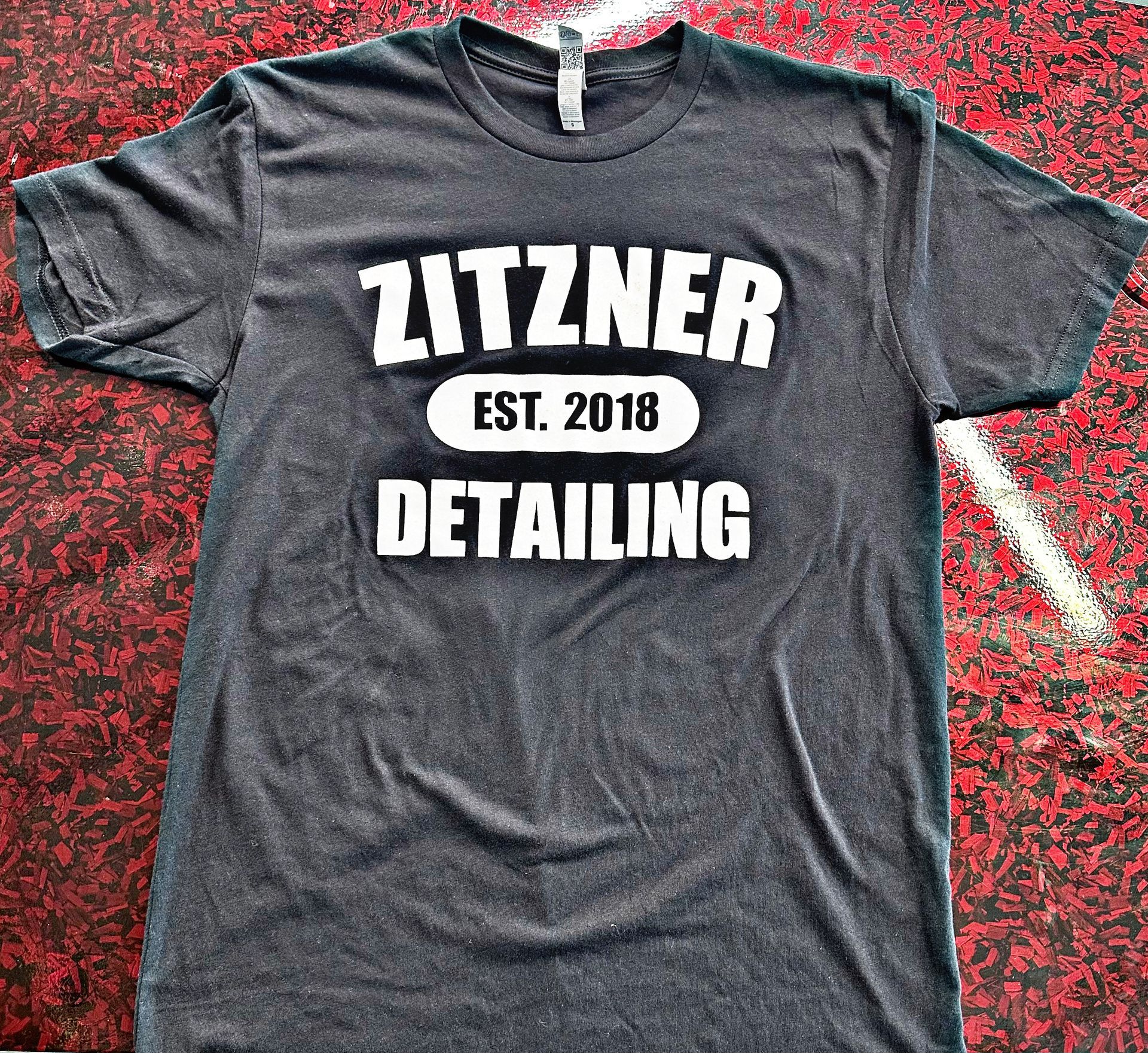 A charcoal gray t-shirt with white text reading 