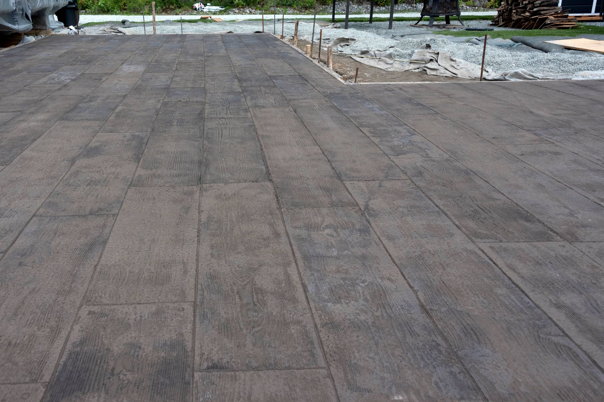A concrete driveway that looks like wood is being built.