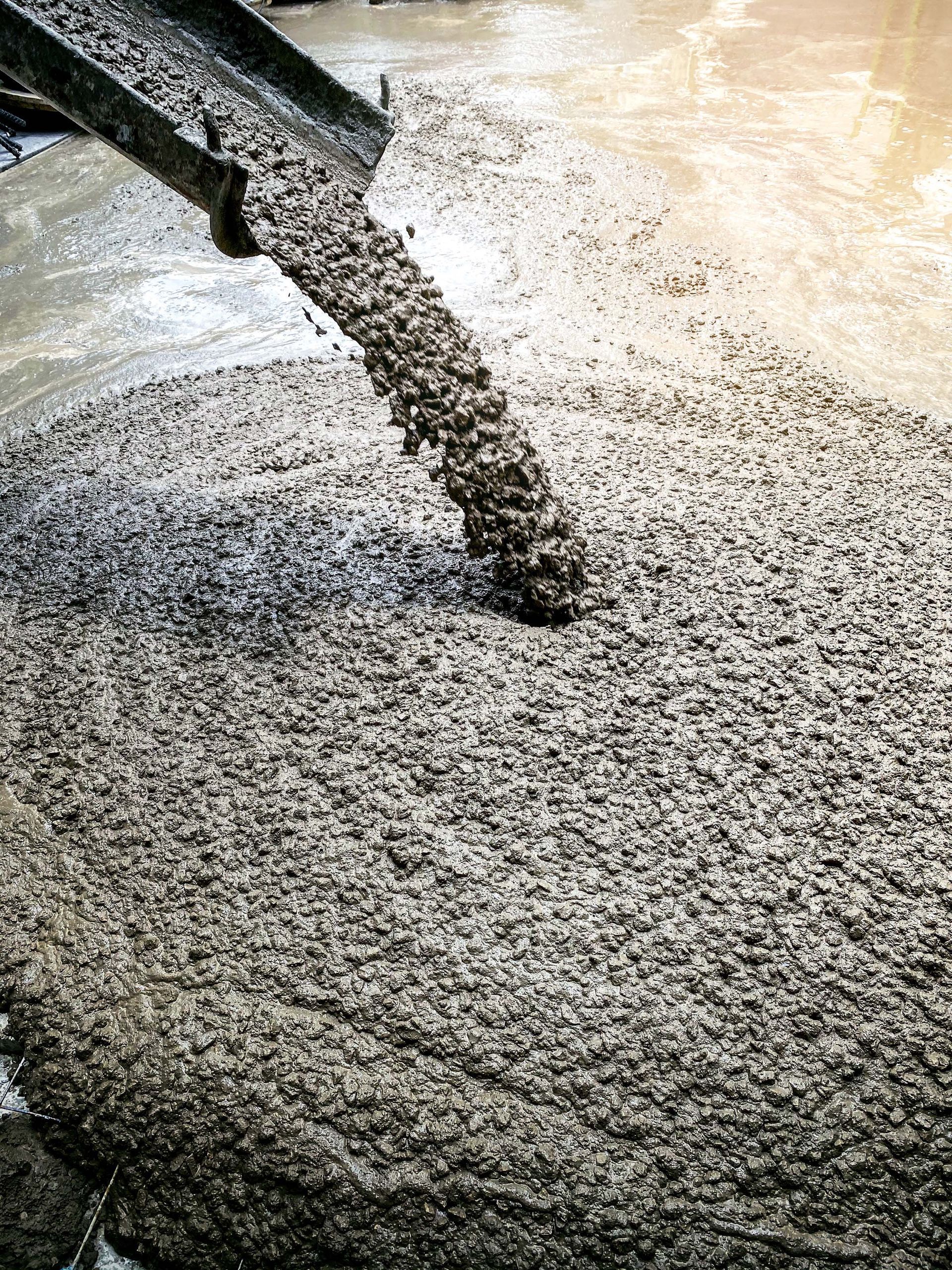 Concrete is being poured into a pile of concrete.