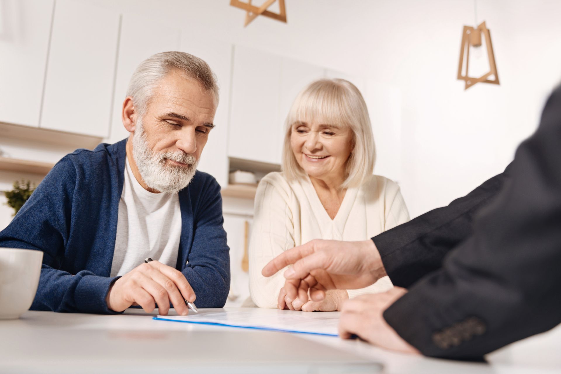 Elderly couple sign document with advisor, representing social security disability lawyer services. Elderly couple sign document with advisor, representing social security disability lawyer services.