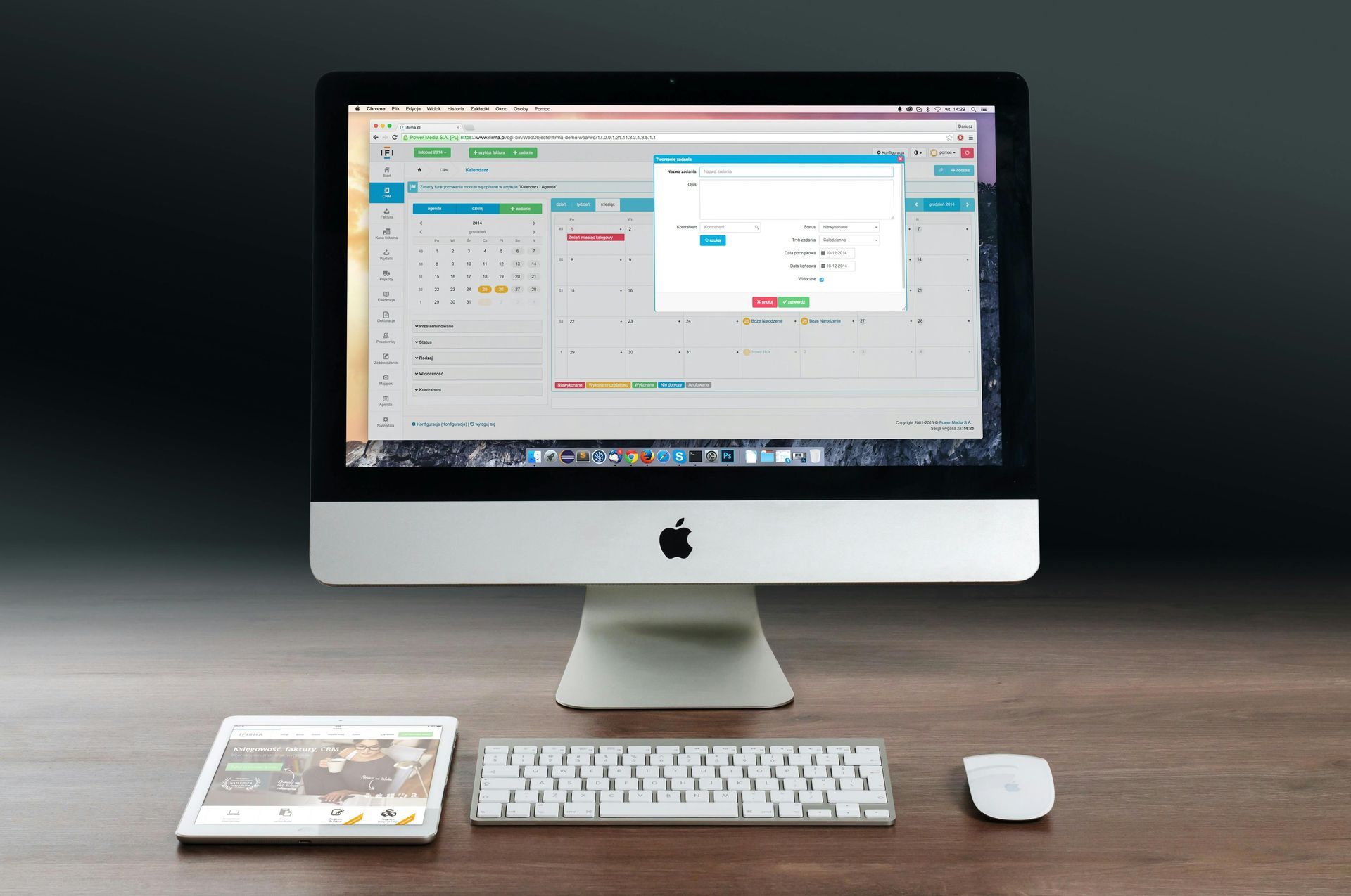 Desktop computer with calendar app open, keyboard, mouse, and tablet on wooden desk.