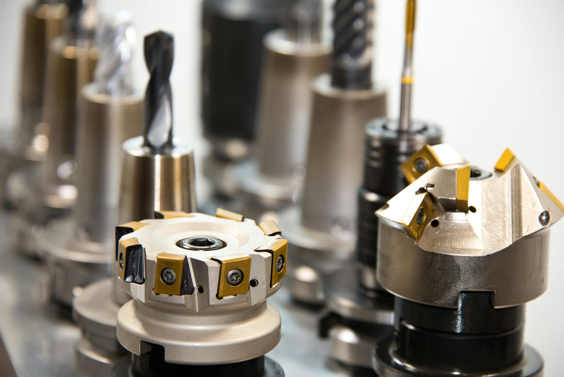 Machining tools: various cutting tools in a row, with silver and gold blades.