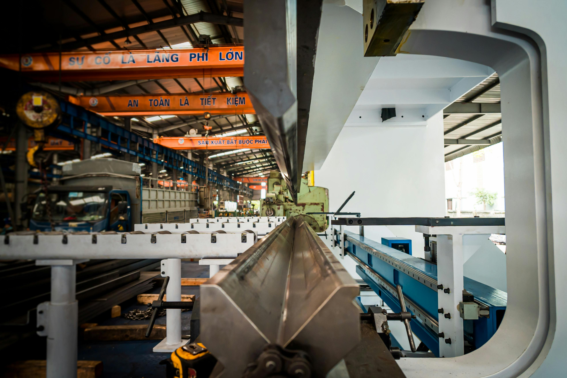 Metal bending machine in an industrial setting, bending metal sheet.