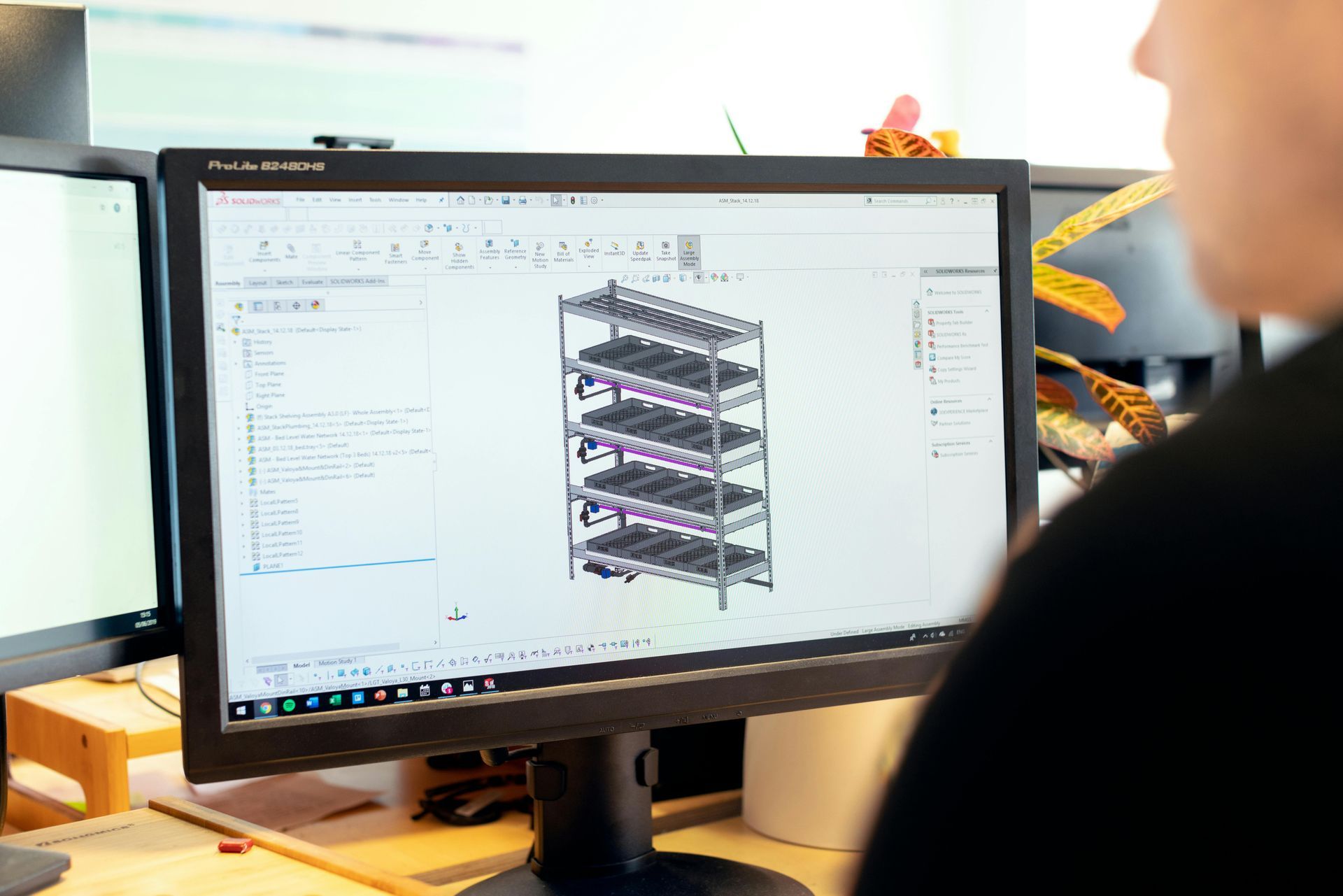 Person designing a multi-level industrial rack on a computer screen.