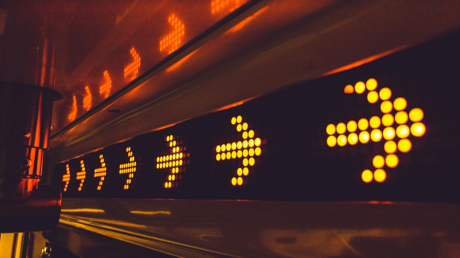 Lit-up yellow arrow signs pointing right inside a dark vehicle, suggesting forward direction.