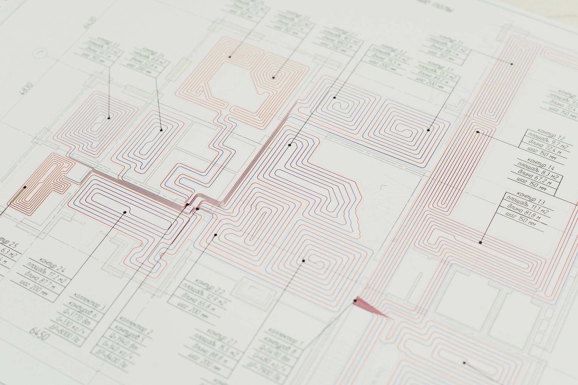 Close-up of a blueprint. Detailed electronic circuit diagram with red and black lines, annotations, and components.