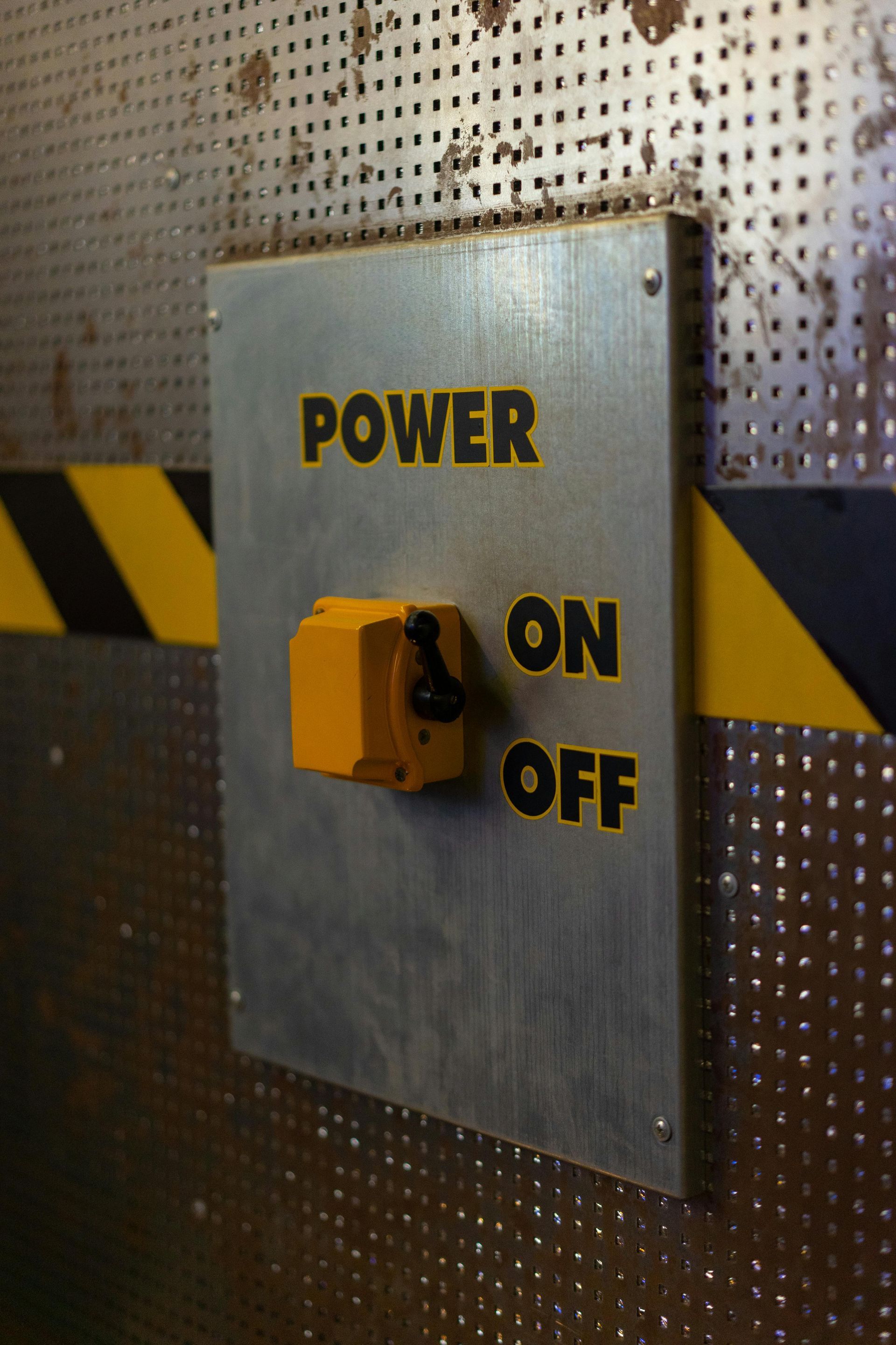 Yellow power switch on a metal plate, labeled