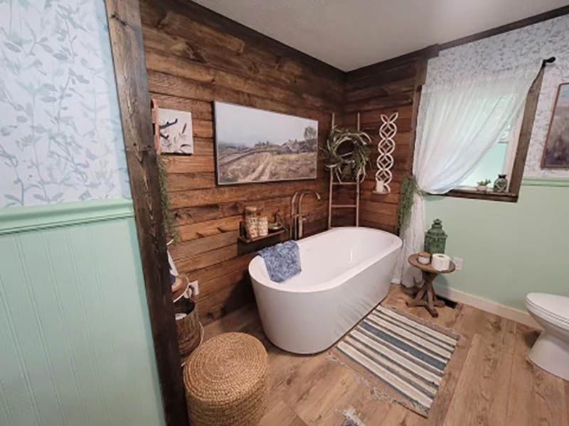 Bathroom with wooden walls, a white tub, and green accents.