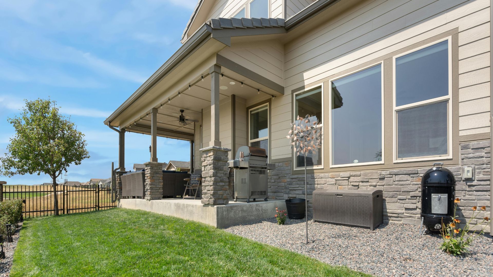 Exterior of a house with a porch, lawn, and blue sky.