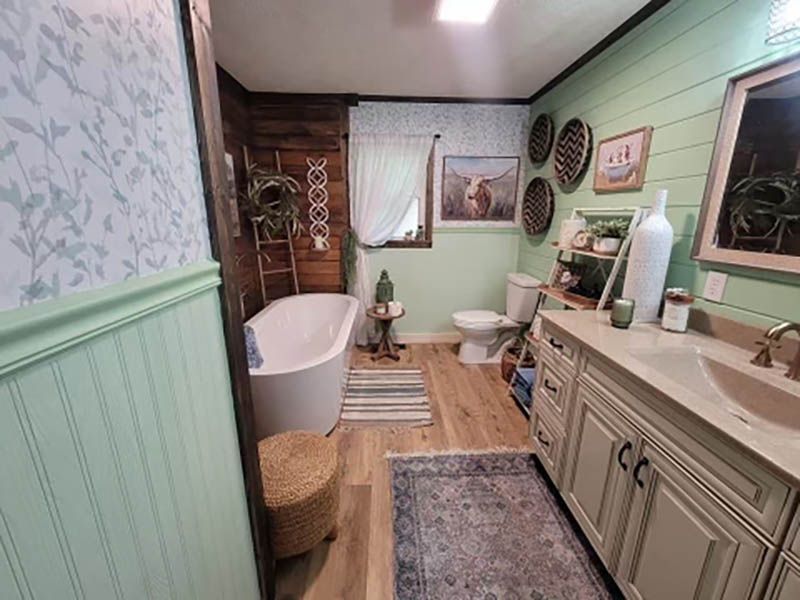 Bathroom with wood and mint green paneling, a free-standing tub, and a double-sink vanity.