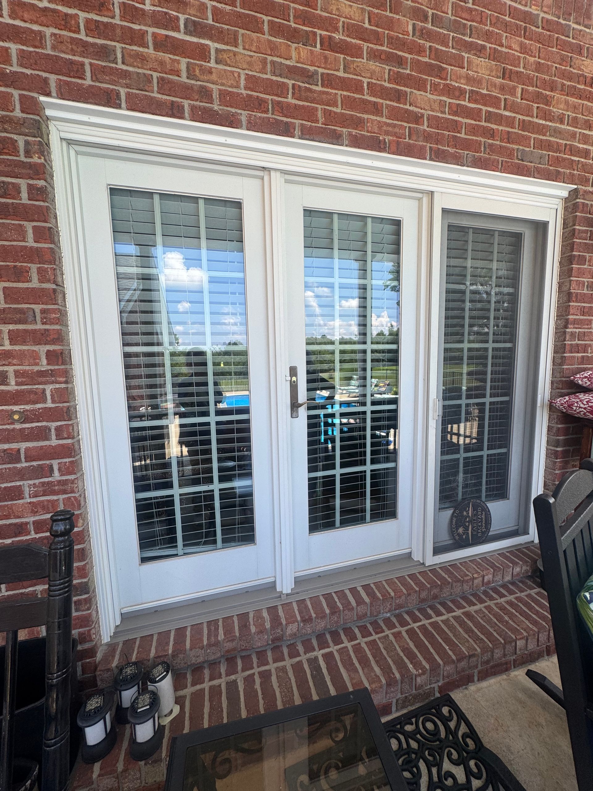 White French doors with sidelight on a brick building's exterior.
