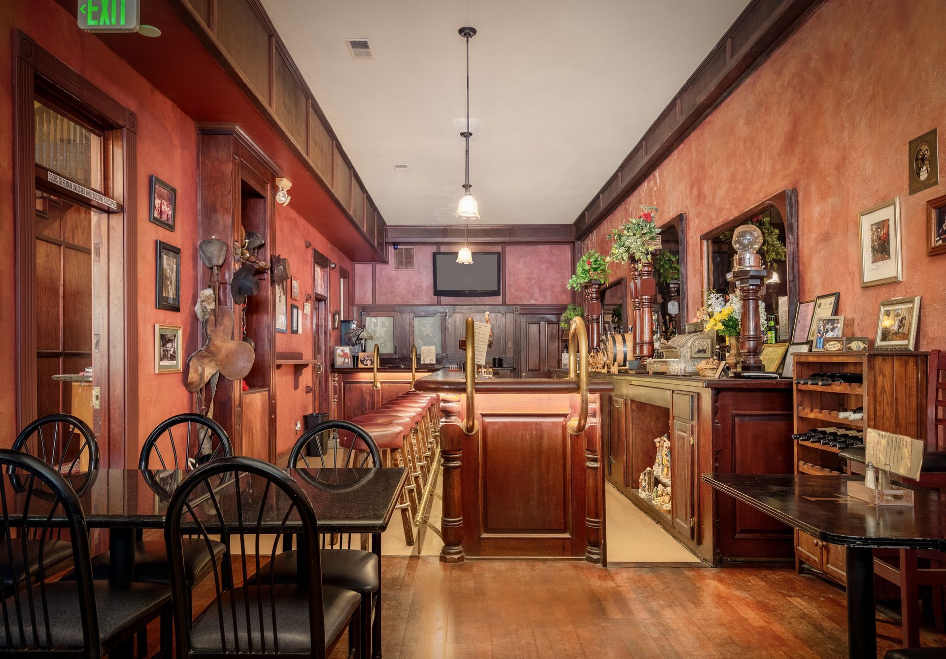 A restaurant with tables and chairs and an exit sign