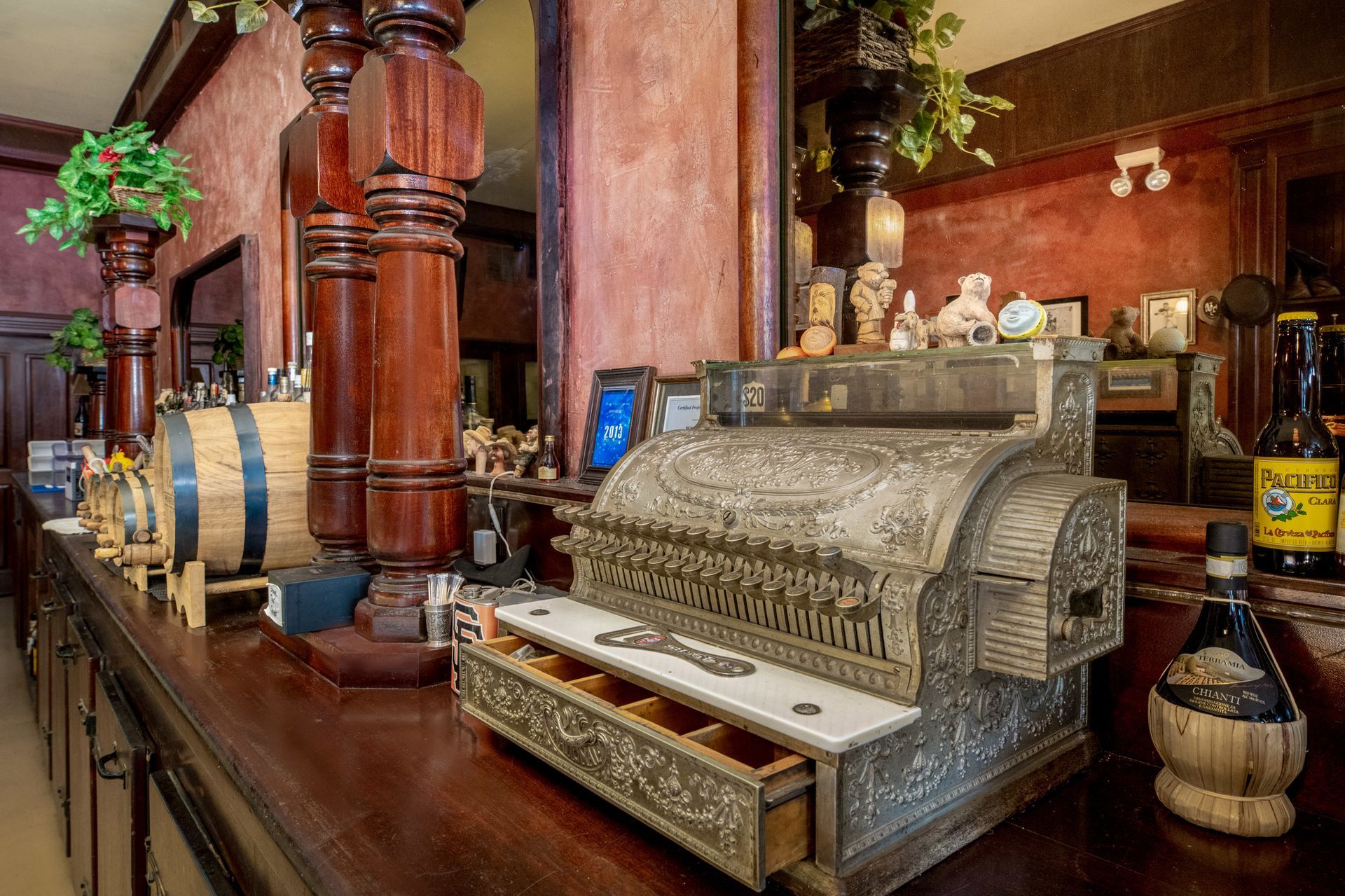 An old cash register is sitting on a wooden table.