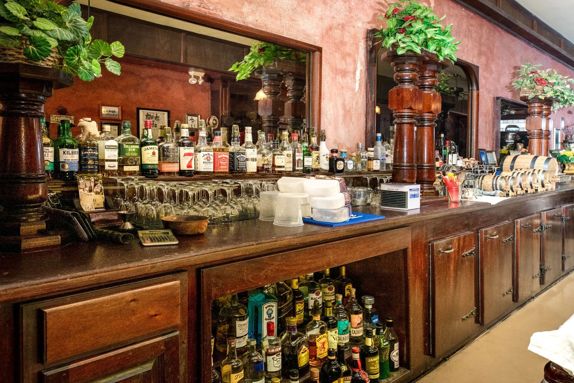 A bar with lots of bottles and glasses on it