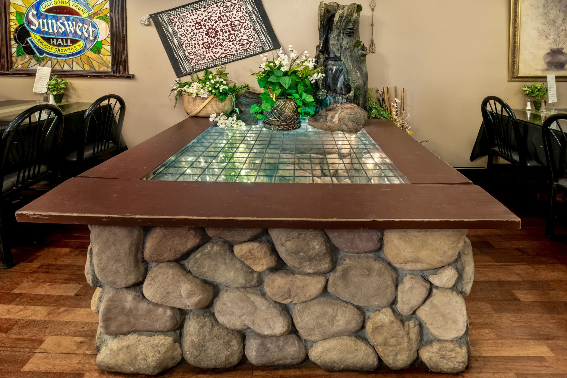 A stone table with a fountain in the middle of it in a restaurant.