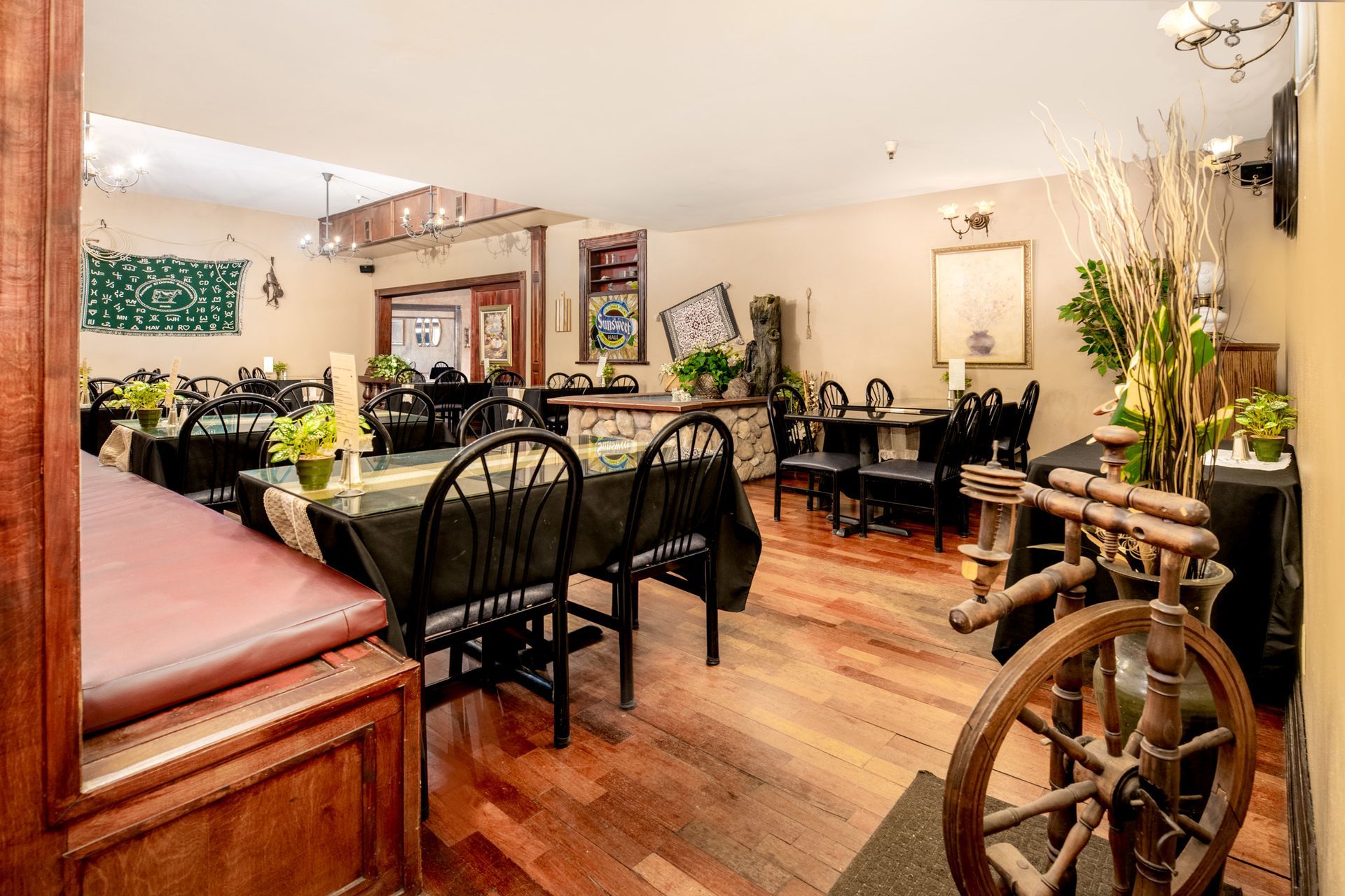 A restaurant with tables and chairs and a spinning wheel in the middle of the room.