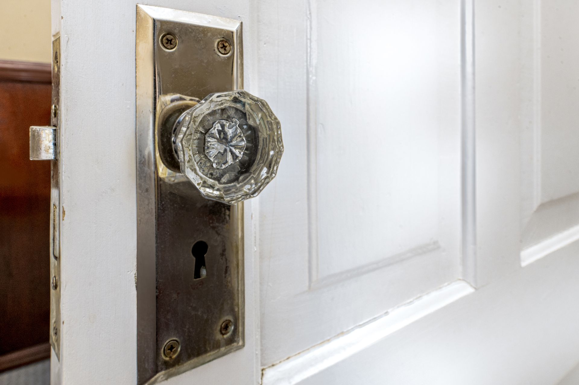 A close up of a door knob on a white door.