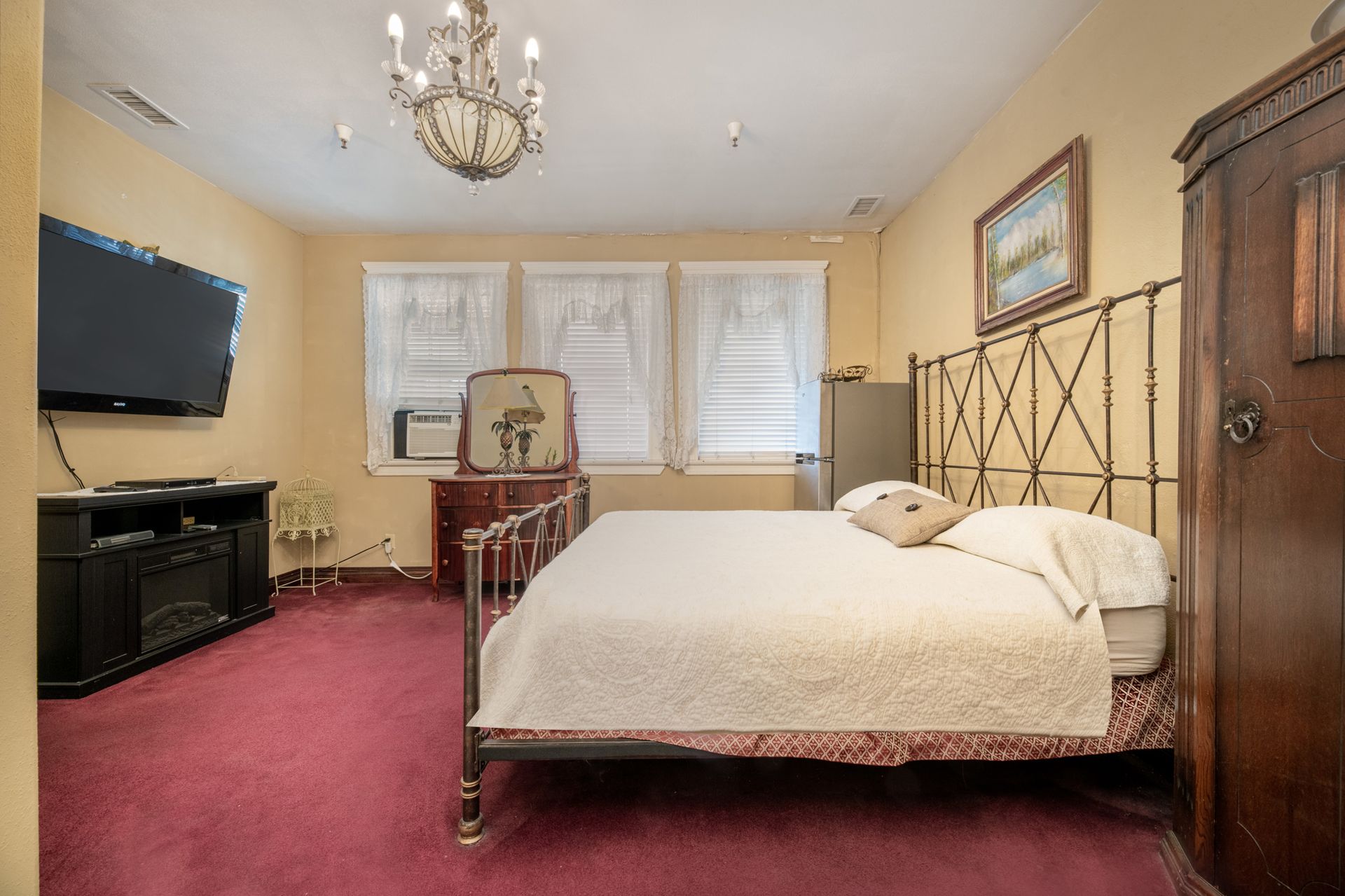 A bedroom with a large bed and a flat screen tv.