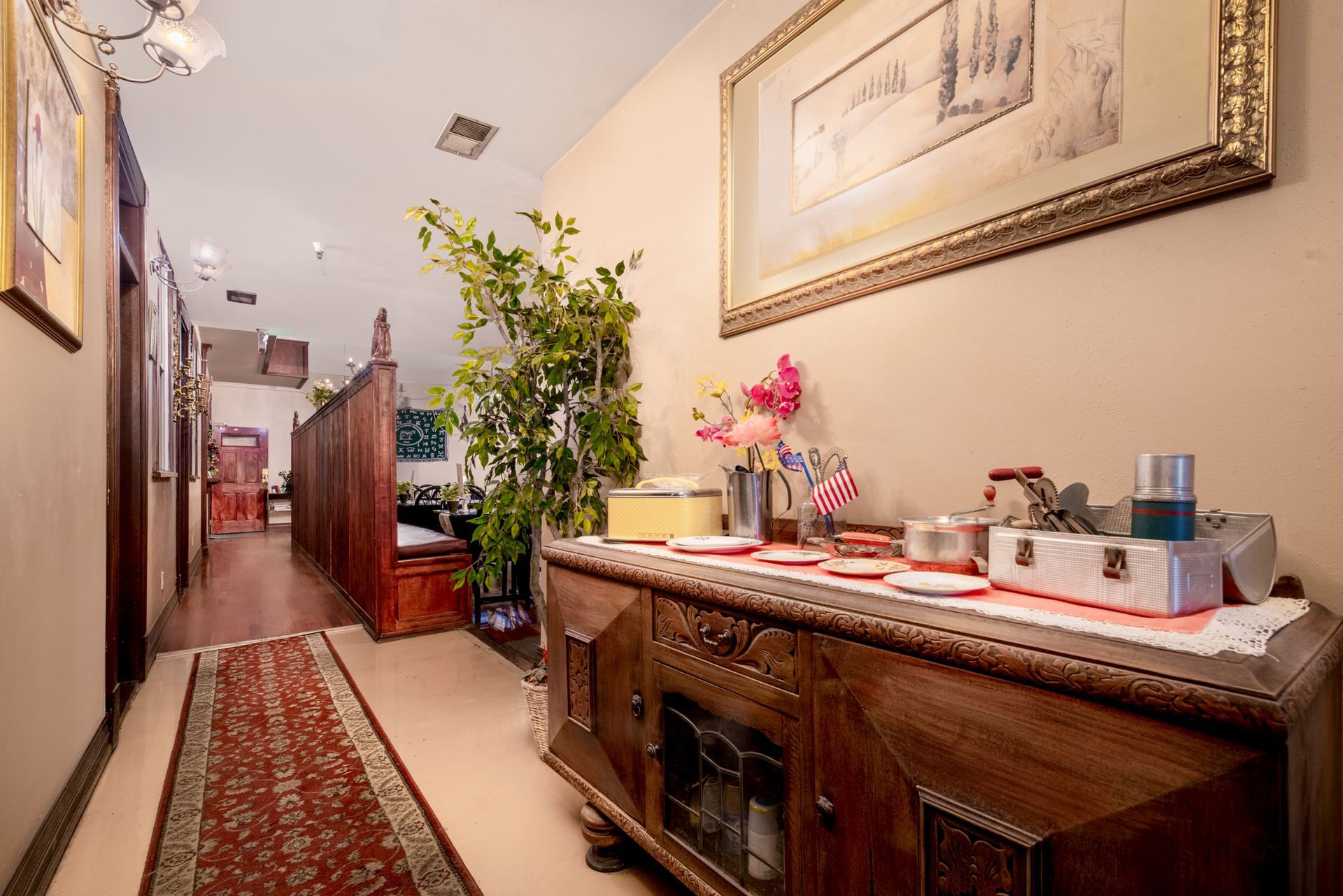A hallway with a dresser and a picture on the wall.