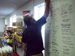A man is writing on a white board in a store