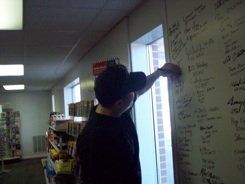 A man is writing on a white board in a store