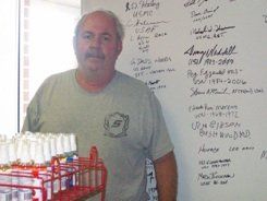 A man standing in front of a white board with writing on it