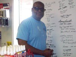 A man is writing on a whiteboard in a store.