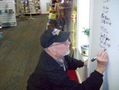 A man is writing on a white board in a store
