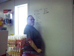A man is standing in front of a whiteboard in a store.