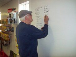 A man is writing on a whiteboard in a store.