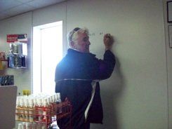 A man is writing on a white board in a store