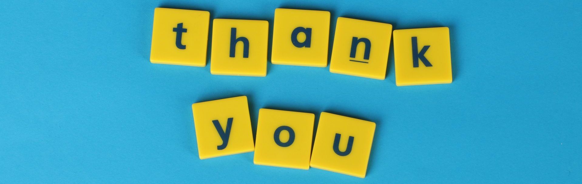 The word thank you is written in yellow blocks on a blue background.