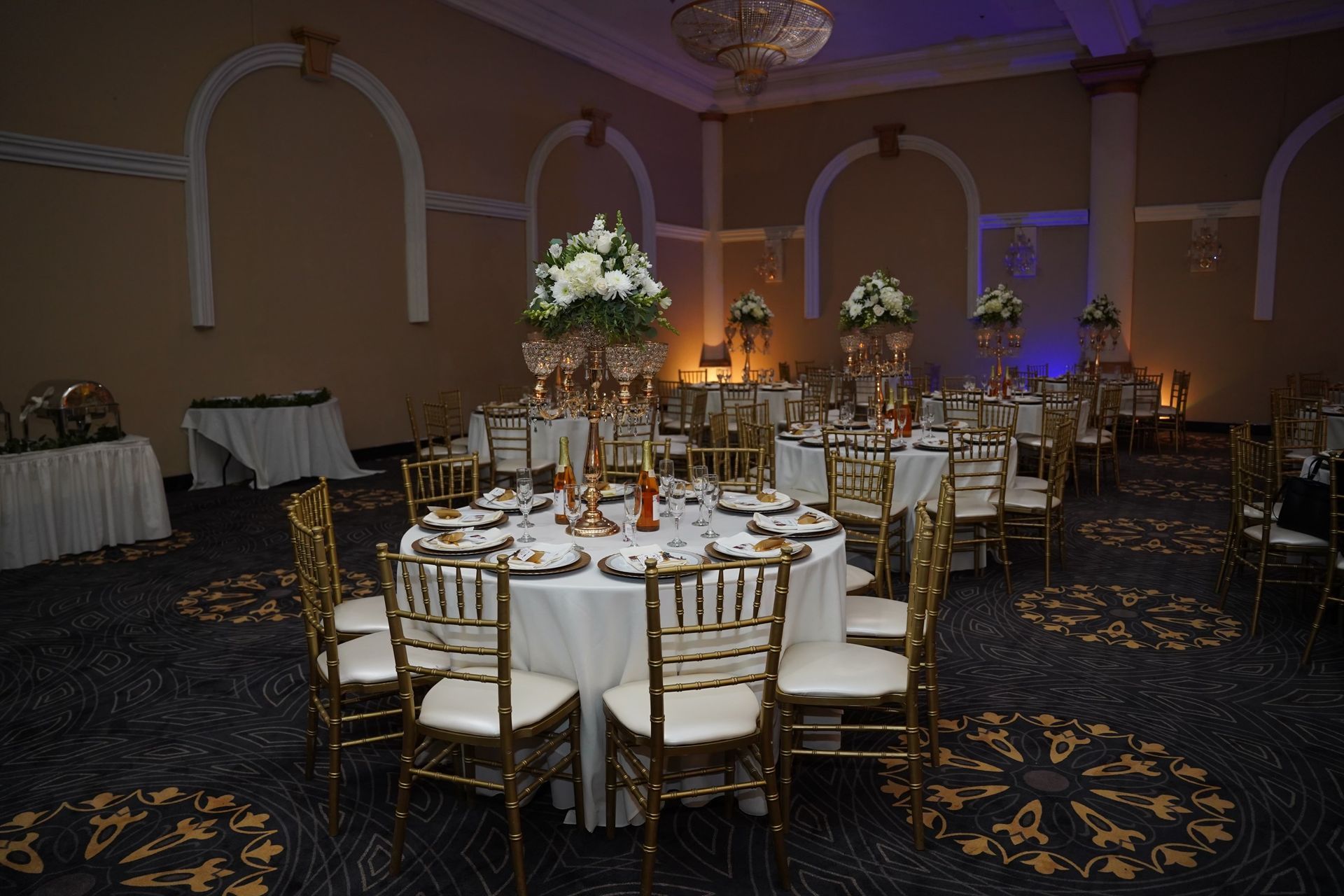 A large room with tables and chairs set up for a wedding reception.