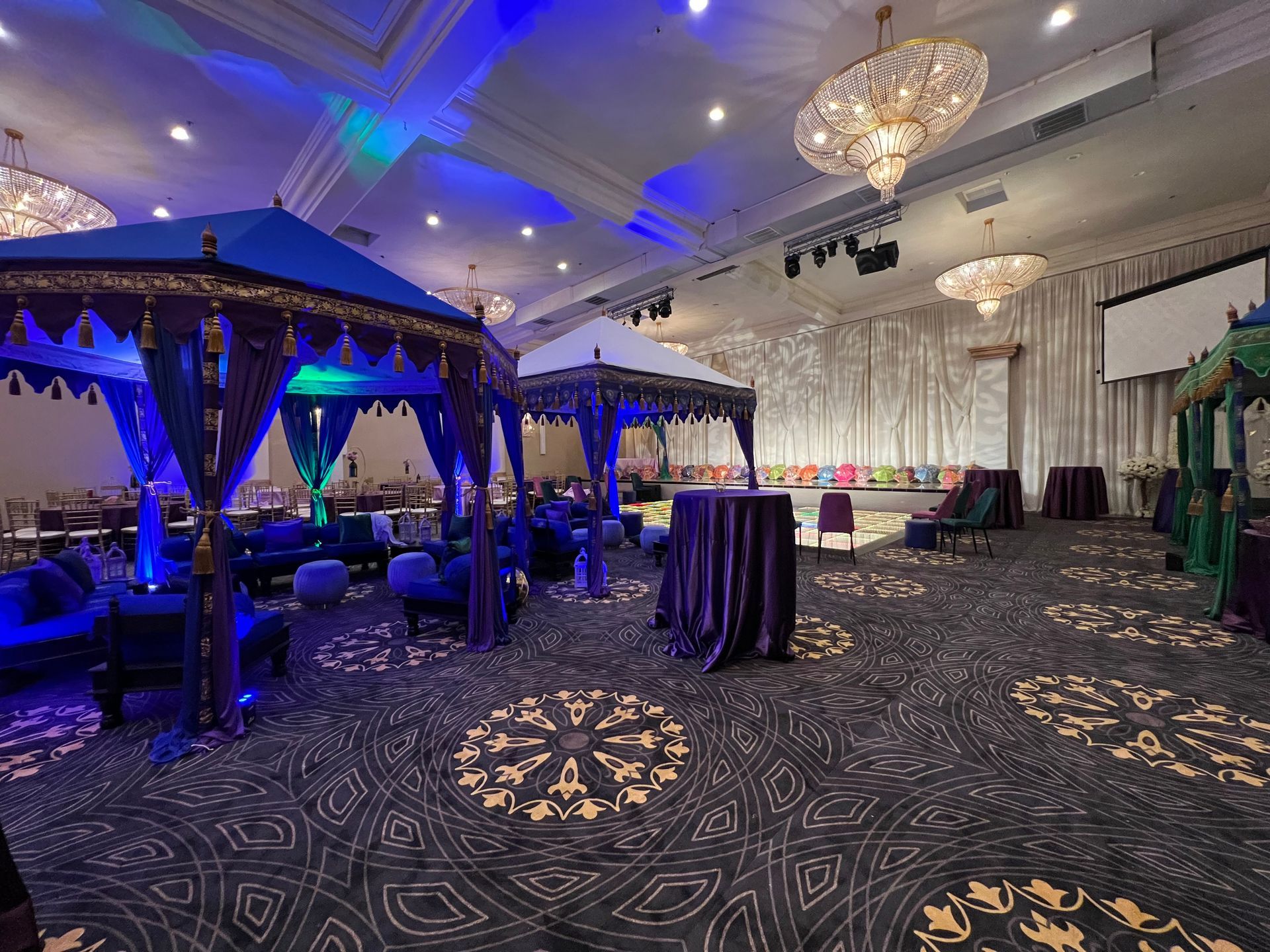 A large room with tables , chairs , and tents in it.