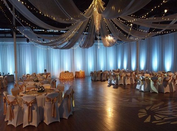 A large room with tables and chairs set up for a wedding reception oceanside