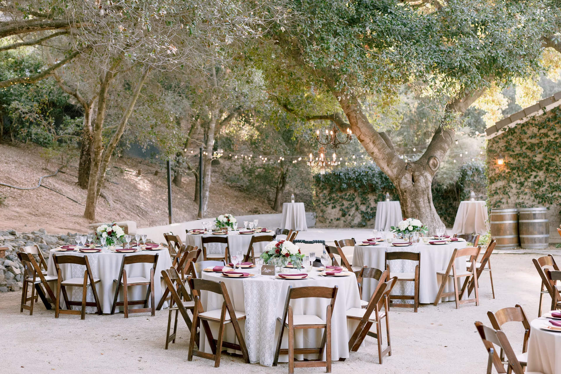 Tables and chairs are set up for a wedding reception outdoors
