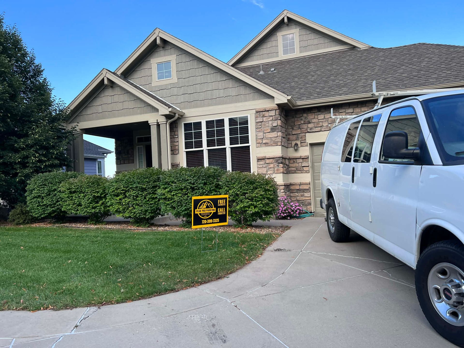Suburban house with a white van parked in the driveway and a yellow yard sign near the bushes