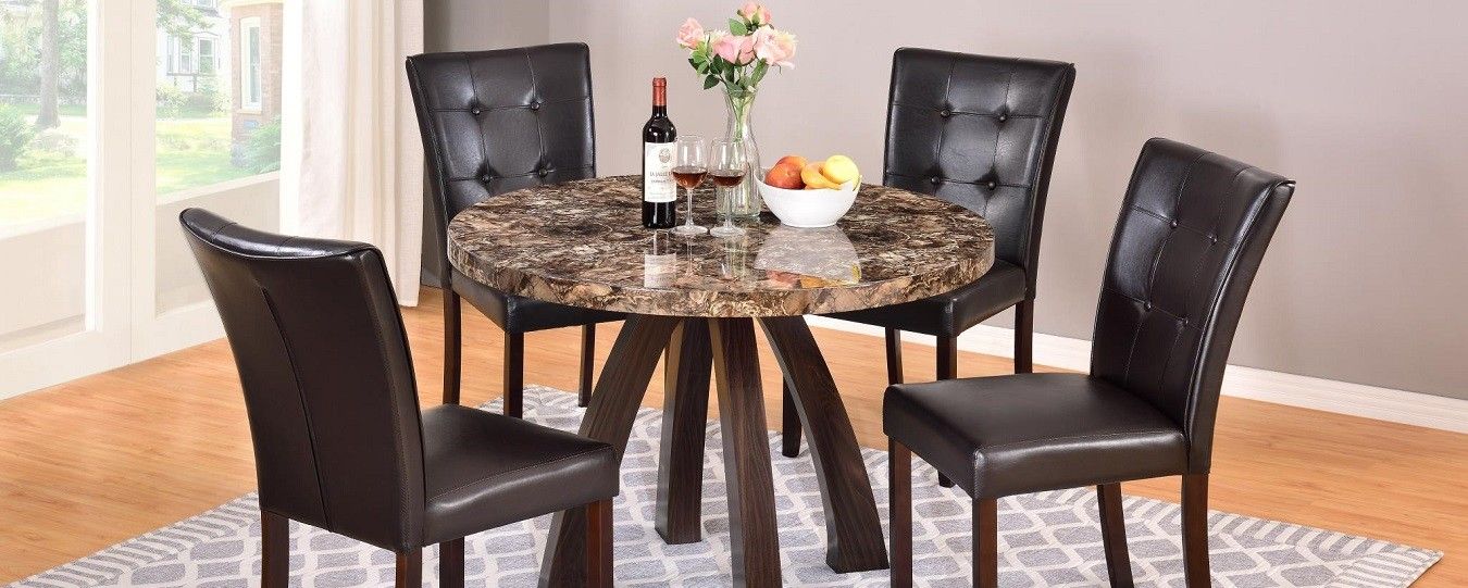 A dining room table with four chairs and a bottle of wine on it.