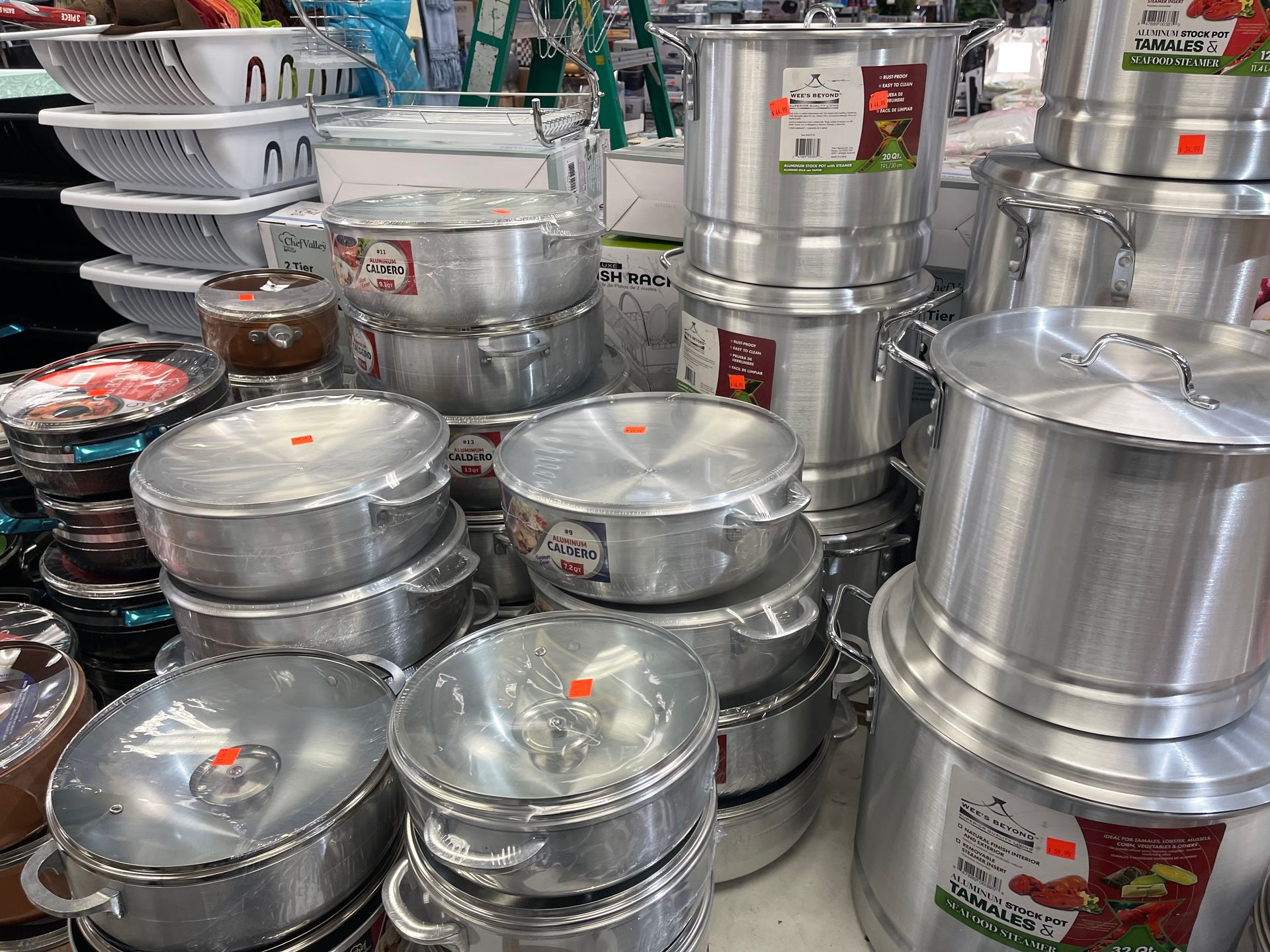 A bunch of pots and pans are stacked on top of each other in a store.