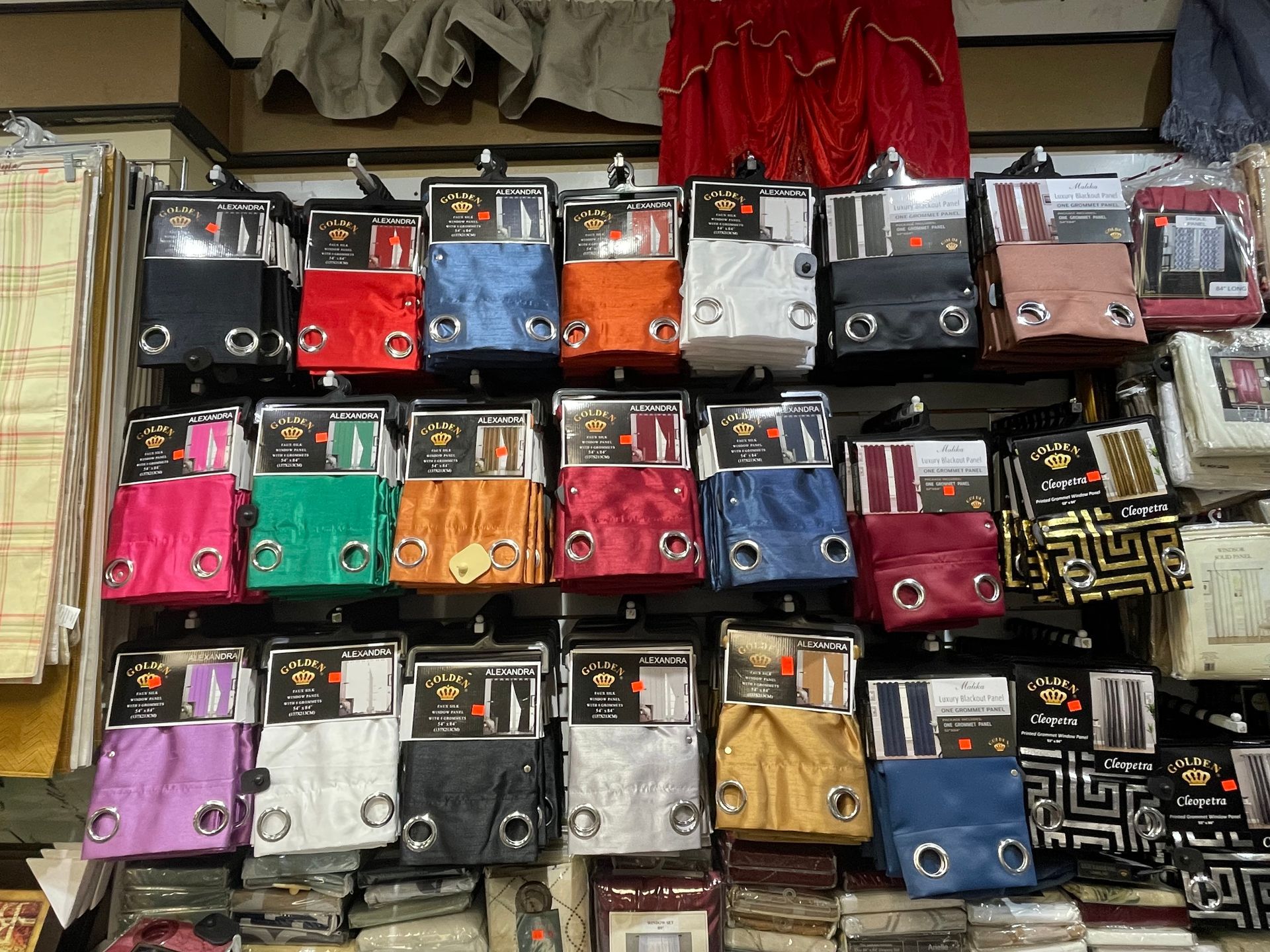 A variety of curtains are hanging on a wall in a store